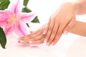 Beautiful woman hands and lily flower over white background
